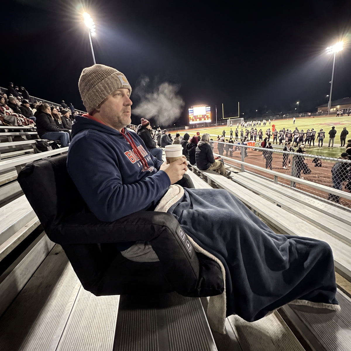 Benchwarmer seat at a night football game